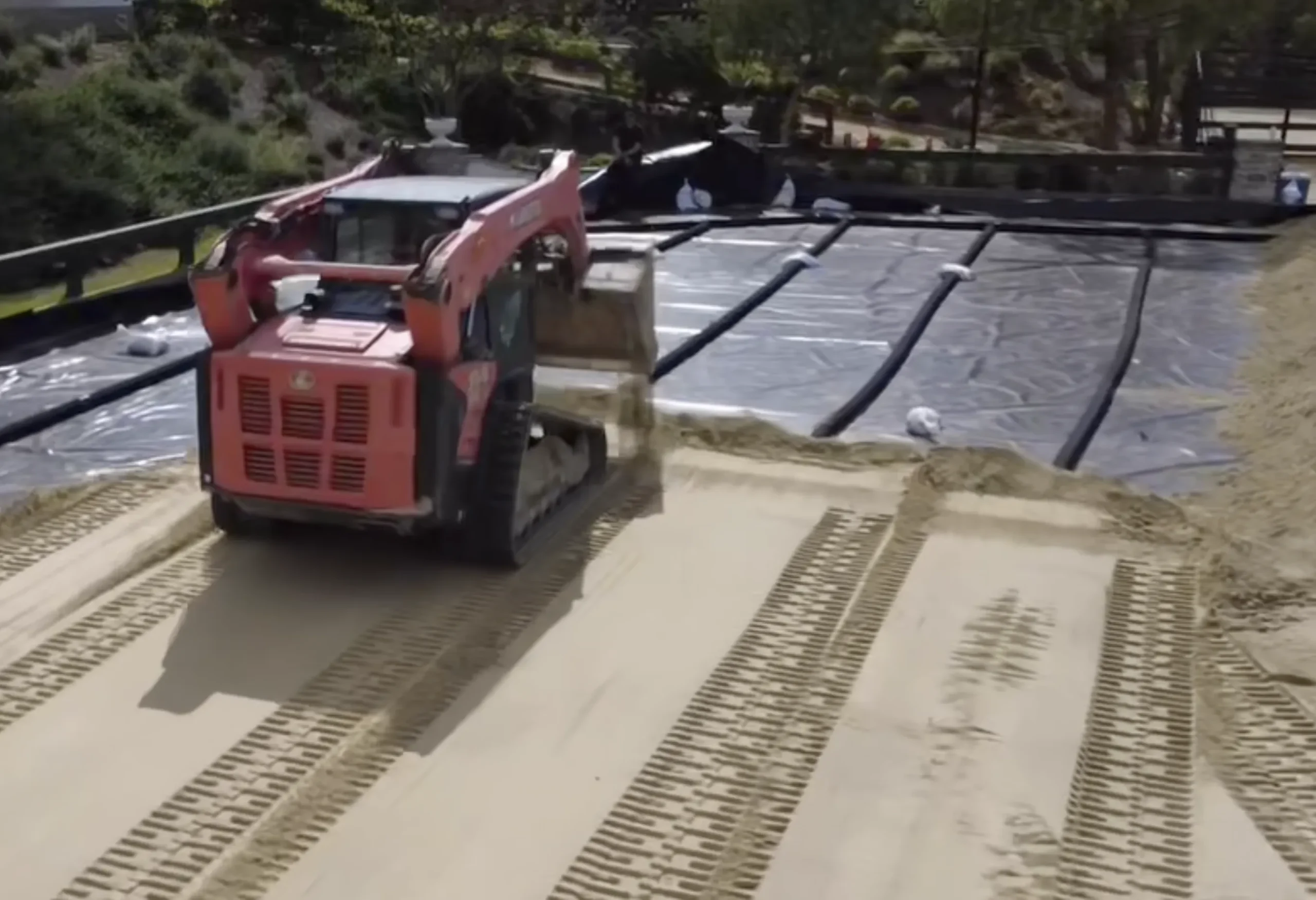 A tractor works a arena footing